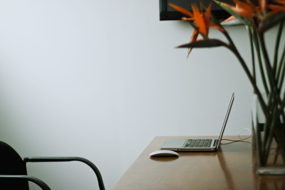 Minimalist office desk with a laptop, notebook and telephone